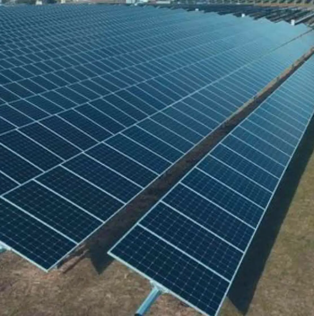 A ground-mount solar array running across open land