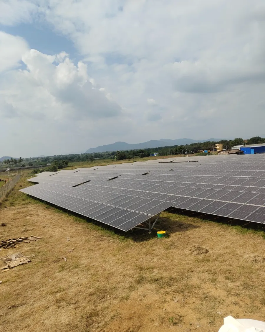 Rows of ground-mounted panels running toward hills on the horizon